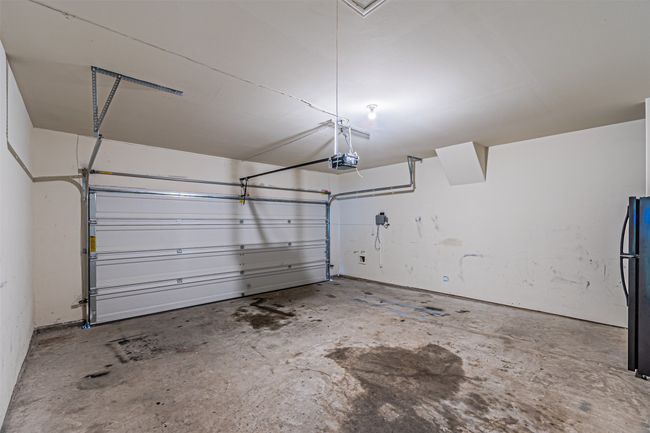 Garage featuring a garage door opener and freestanding refrigerator | Image 12