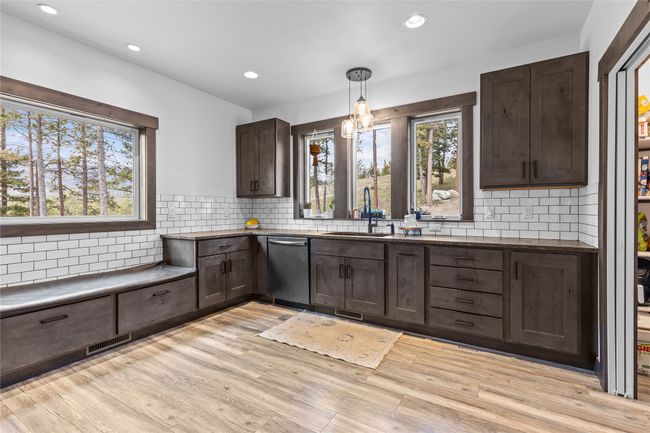 Kitchen with dark brown cabinets, plenty of natural light, dishwasher, and a sink | Image 6