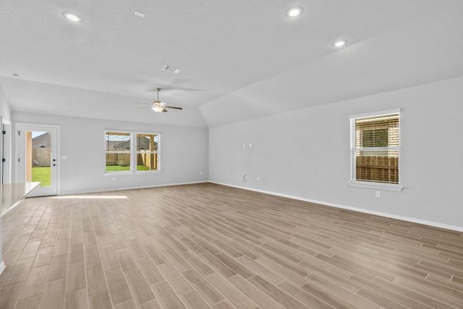 Unfurnished living room with light wood-type flooring, baseboards, recessed lighting, visible vents, and lofted ceiling | Image 13