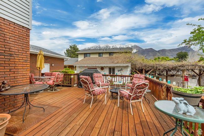 Wooden terrace featuring outdoor dining area, a mountain view, and an outdoor hangout area | Image 5