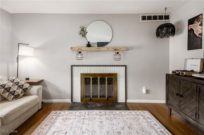 Living room featuring a fireplace and dark hardwood flooring | Image 3