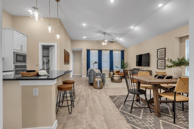 Dining space featuring lofted ceiling, light wood-type flooring, a ceiling fan, and recessed lighting | Image 4