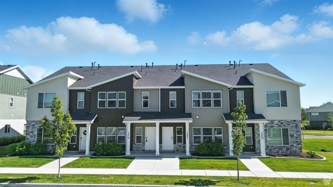 View of property with stone siding, a front yard, and a shingled roof | Image 24