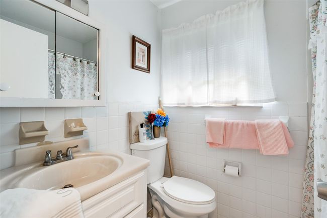 Full bathroom featuring tile walls, vanity, and curtained shower | Image 16