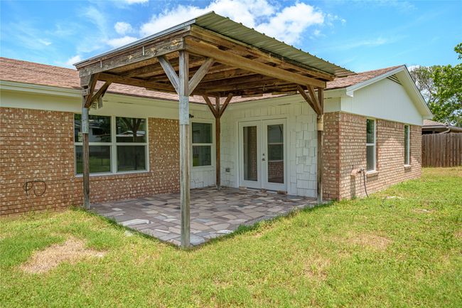 Rear view of house featuring french doors, brick siding, and a patio area | Image 12