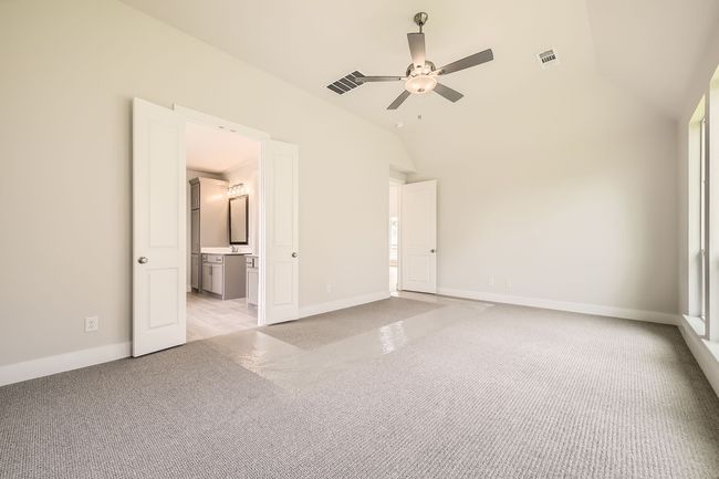 Unfurnished bedroom featuring light carpet, vaulted ceiling, and connected bathroom | Image 16