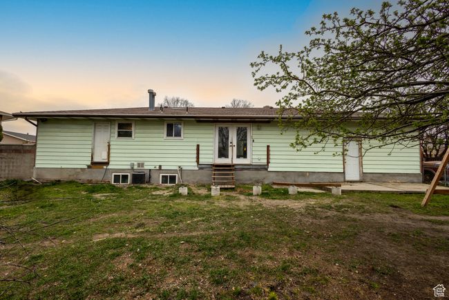 Rear view of house with entry steps, french doors, and a yard | Image 28