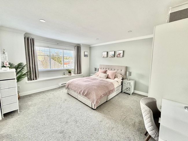 Bedroom with crown molding, carpet, and a baseboard radiator | Image 16