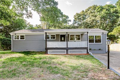 Ranch-style home featuring a front lawn and covered porch | Image 1