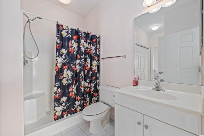 Full bath featuring tile patterned flooring, vanity, toilet, and a shower with shower curtain | Image 13