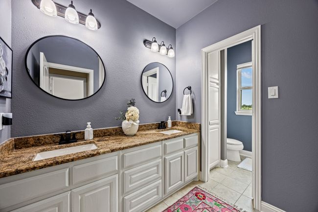 Bathroom featuring tile patterned floors, double vanity, toilet, and baseboards | Image 10