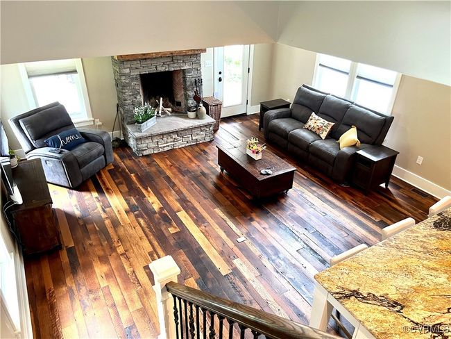 Living room with reclaimed oak wood-style flooring, plenty of natural light, and a stone fireplace | Image 36