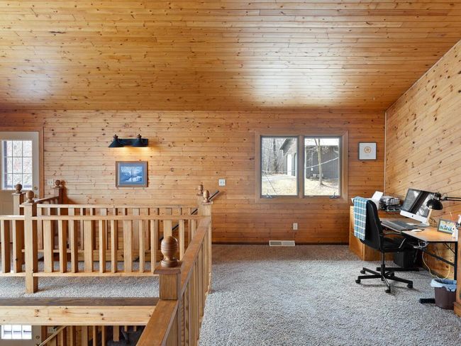 The loft is being used as a dual-purpose space—office in one corner, library in the other. | Image 37