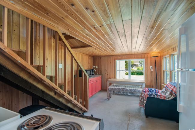 Miscellaneous room with wood ceiling, concrete floors, wood walls, and stairway | Image 7
