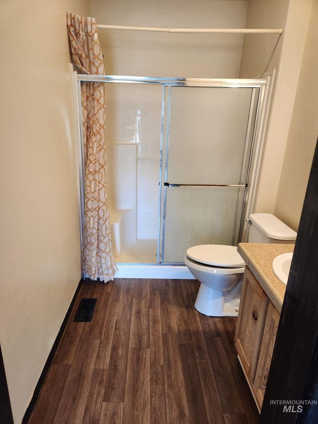 Bathroom featuring vanity, wood finished floors, and a shower stall | Image 6