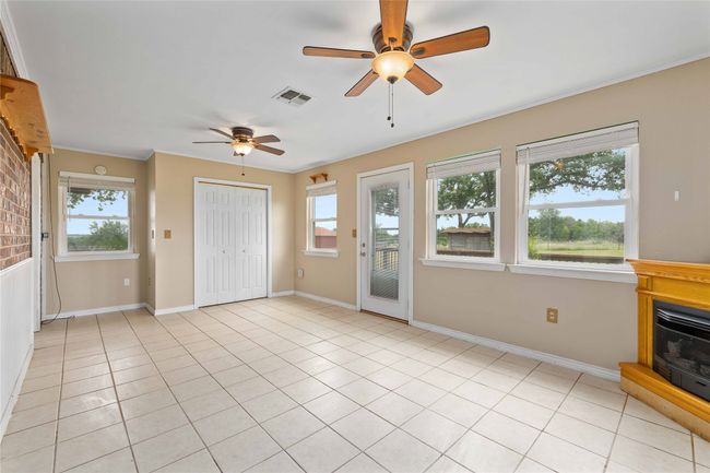 Unfurnished living room with ceiling fan, healthy amount of natural light, crown molding, and light tile patterned floors | Image 20