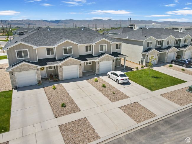 View of property featuring a mountain view, board and batten siding, driveway, stone siding, and a shingled roof | Image 7
