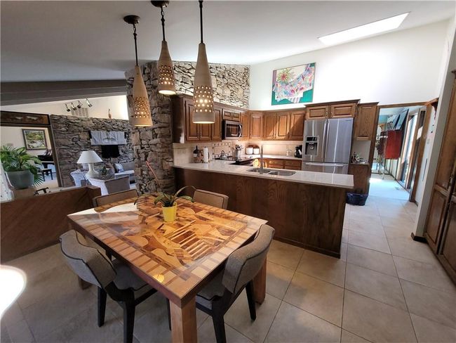 Dining space featuring a skylight, a towering ceiling, and light tile patterned floors | Image 20