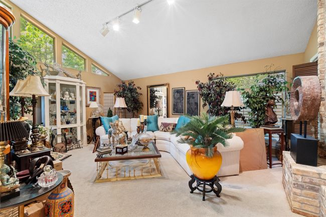 Carpeted living room featuring a textured ceiling, rail lighting, and high vaulted ceiling | Image 10