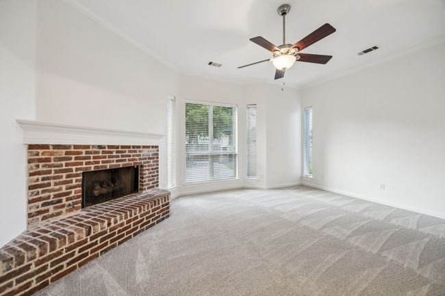 Primary bedroom with carpet, ceiling fan, crown molding, and a fireplace | Image 15