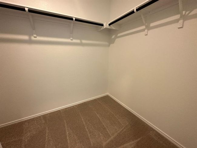 Walk in closet featuring dark carpet | Image 26