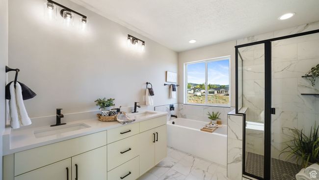 Bathroom featuring marble look tiles, a bath, a marble finish shower, recessed lighting, and double vanity | Image 20