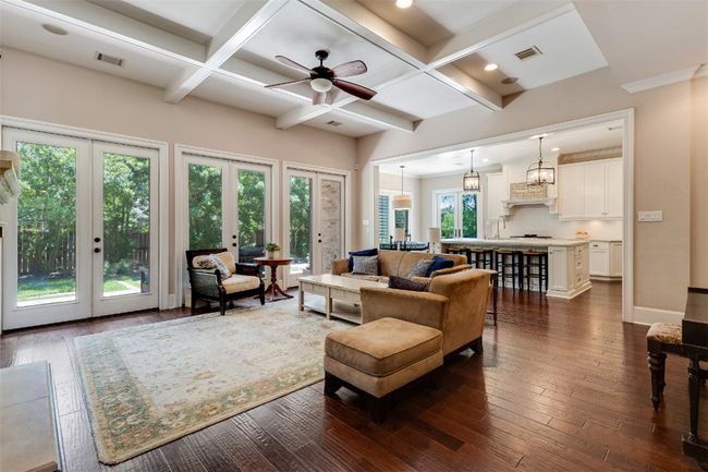 Living room featuring french doors, coffered ceiling, ceiling fan, dark wood-type flooring, and beamed ceiling | Image 9