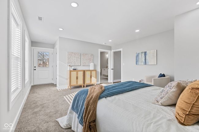 Primary bedroom en-suite with tons of natural light, baseboards, recessed lighting, visible vents, and carpet | Image 19
