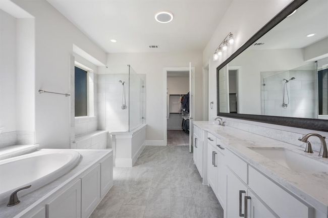 Bathroom with a tile shower, a walk in closet, a garden tub, and double vanity | Image 17