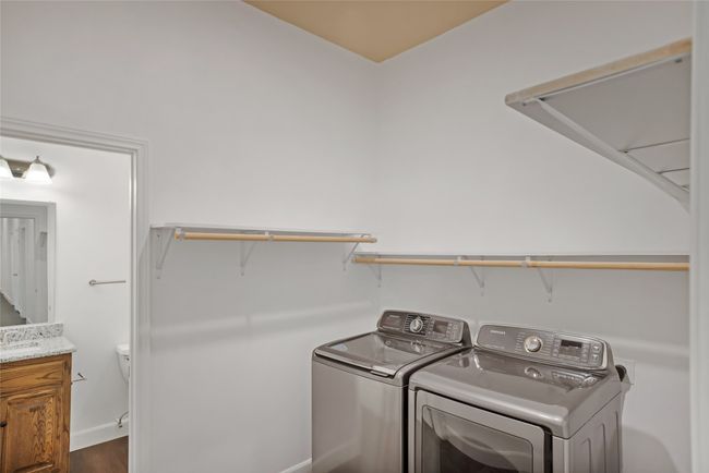 Laundry area featuring washer and dryer and dark wood-style floors | Image 26