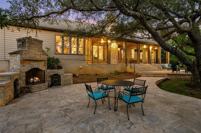 View of patio with an outdoor stone fireplace and outdoor dining space | Image 38