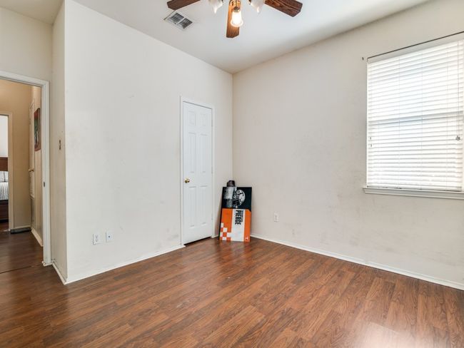 Unfurnished room featuring dark wood-style flooring, a ceiling fan, visible vents, and baseboards | Image 16