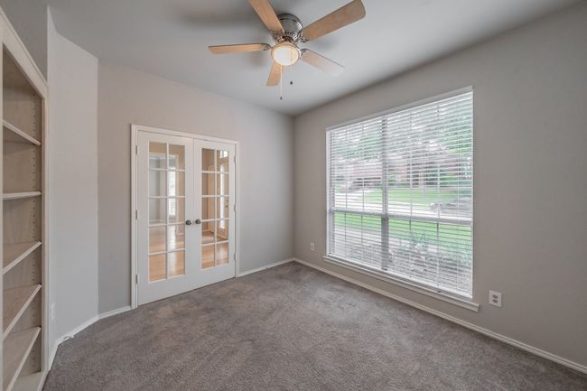 Office with french doors, built in shelves, carpet, and ceiling fan for added comfort. | Image 6