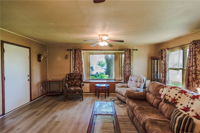 Living room with a ceiling fan and wood finished floors | Image 14