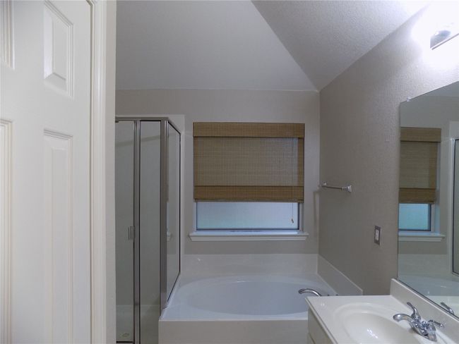 Full bathroom featuring vaulted ceiling, a garden tub, vanity, and a shower stall | Image 24