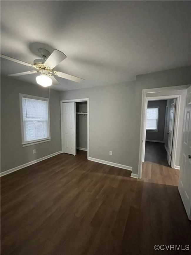 Unfurnished bedroom featuring dark wood-style flooring, a closet, and ceiling fan | Image 4
