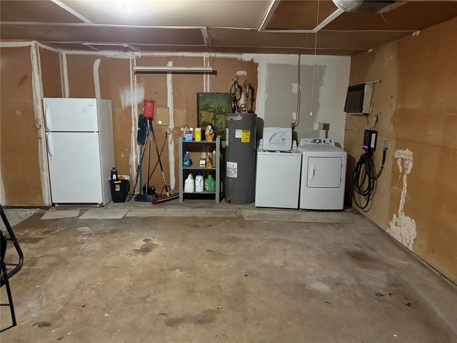 garae featuring freestanding refrigerator, electric water heater, a garage, and separate washer and dryer | Image 20