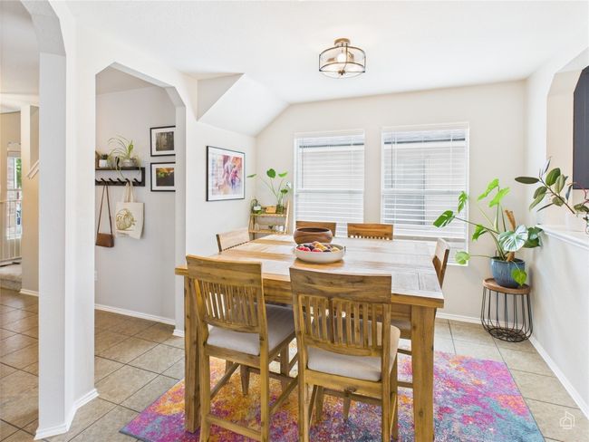 Dining room with light tile patterned floors and arched walkways | Image 6