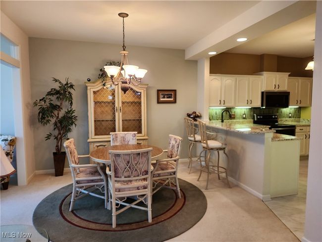 Dining room featuring a chandelier, recessed lighting, and light carpet. | Image 8