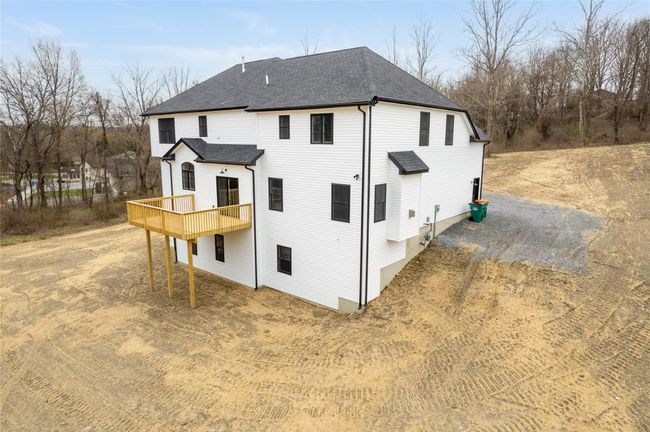 Back of property with driveway, a deck, and roof with shingles | Image 39