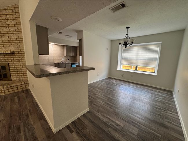 Kitchen featuring dark countertops, dark wood-style floors, baseboards, and a textured ceiling | Image 11