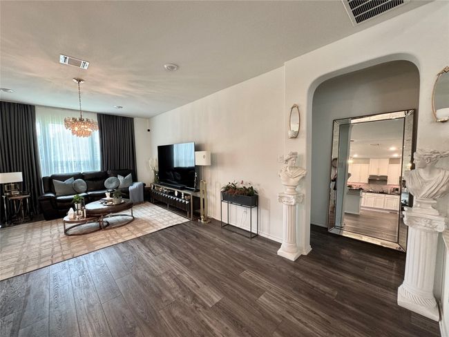 Living room featuring arched walkways, dark wood-style floors, and a chandelier | Image 9