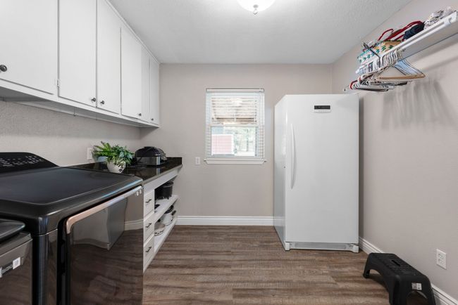 Laundry with granite countertops and plenty of storage cabinets. Room for freezer and hanging clothes rack. | Image 33