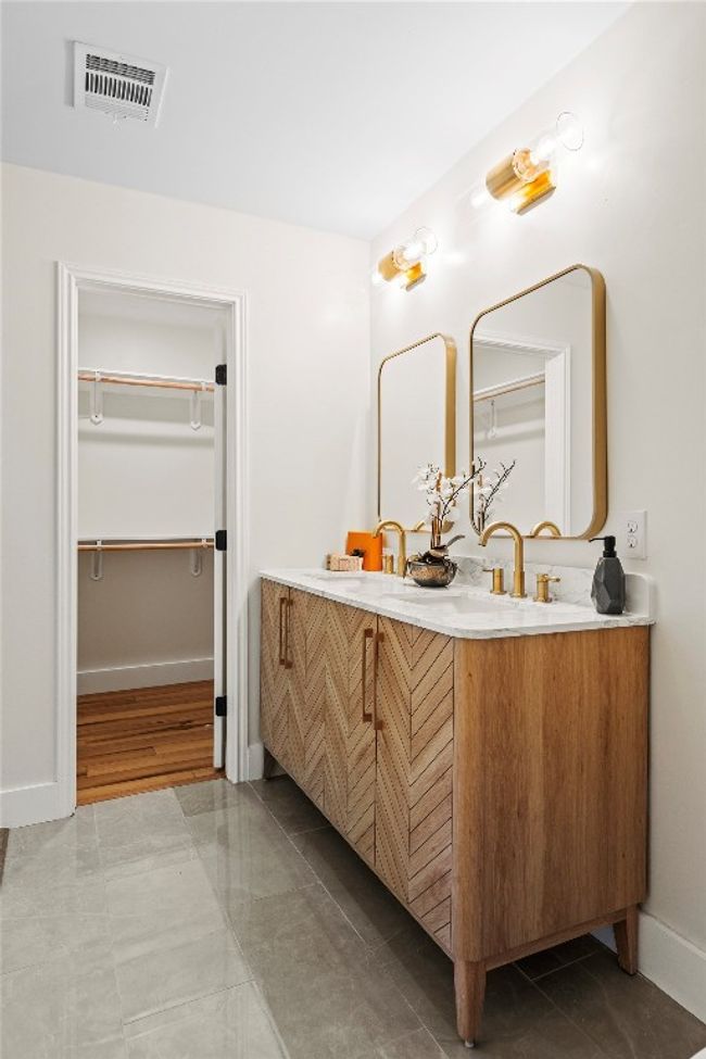 Full bath with double vanity, baseboards, and a spacious closet | Image 24