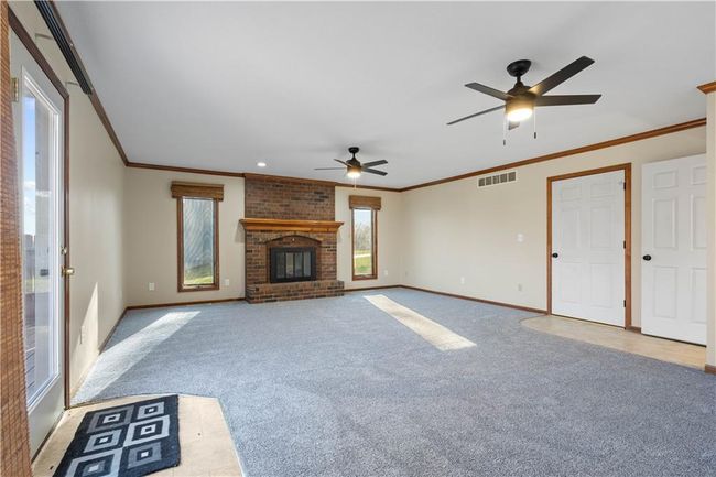 Unfurnished living room with light carpet, baseboards, a ceiling fan, and visible vents | Image 16