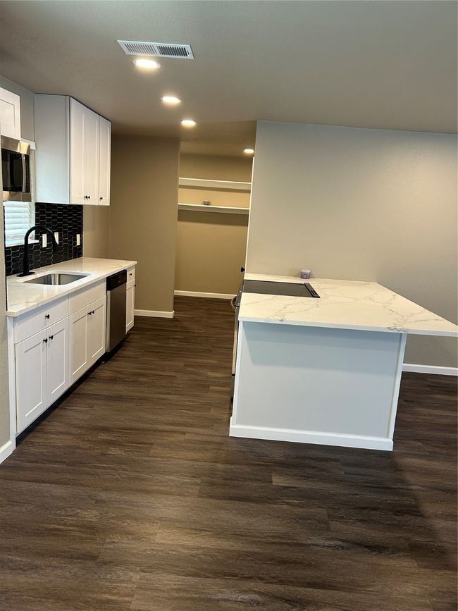 Kitchen featuring dishwashing machine, a sink, baseboards, dark wood finished floors, and recessed lighting | Image 17