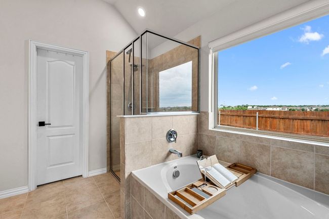 Full bathroom with a stall shower, tile patterned floors, a garden tub, baseboards, and lofted ceiling | Image 22