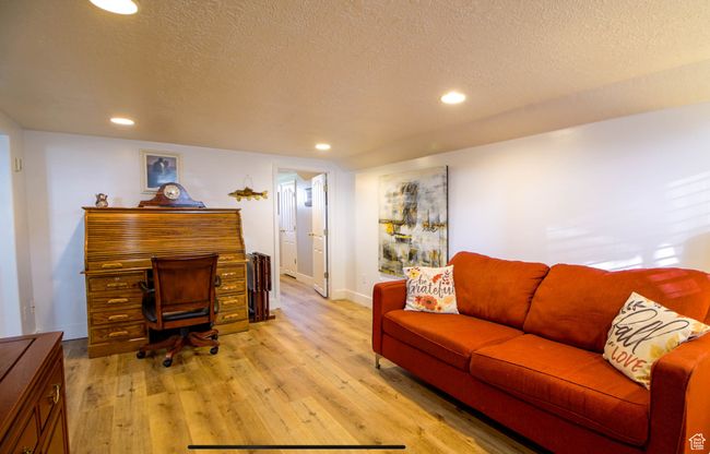 Home office with a textured ceiling, light wood-type flooring, recessed lighting, and baseboards | Image 26