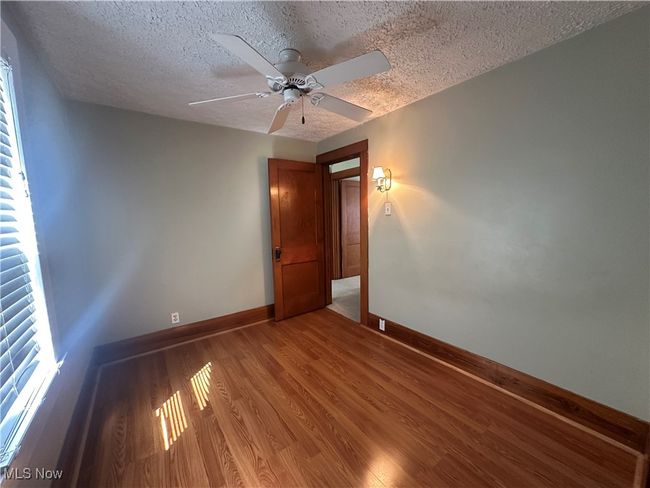 Spare room featuring ceiling fan, baseboards, a textured ceiling, and light wood-style flooring | Image 15