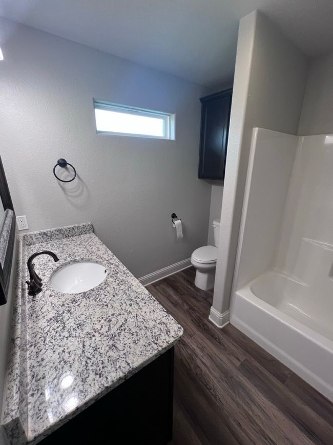 Full bath featuring vanity, wood finished floors, toilet, shower / tub combination, and baseboards | Image 38